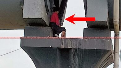 A woman was sitting between the pillars of the flyover