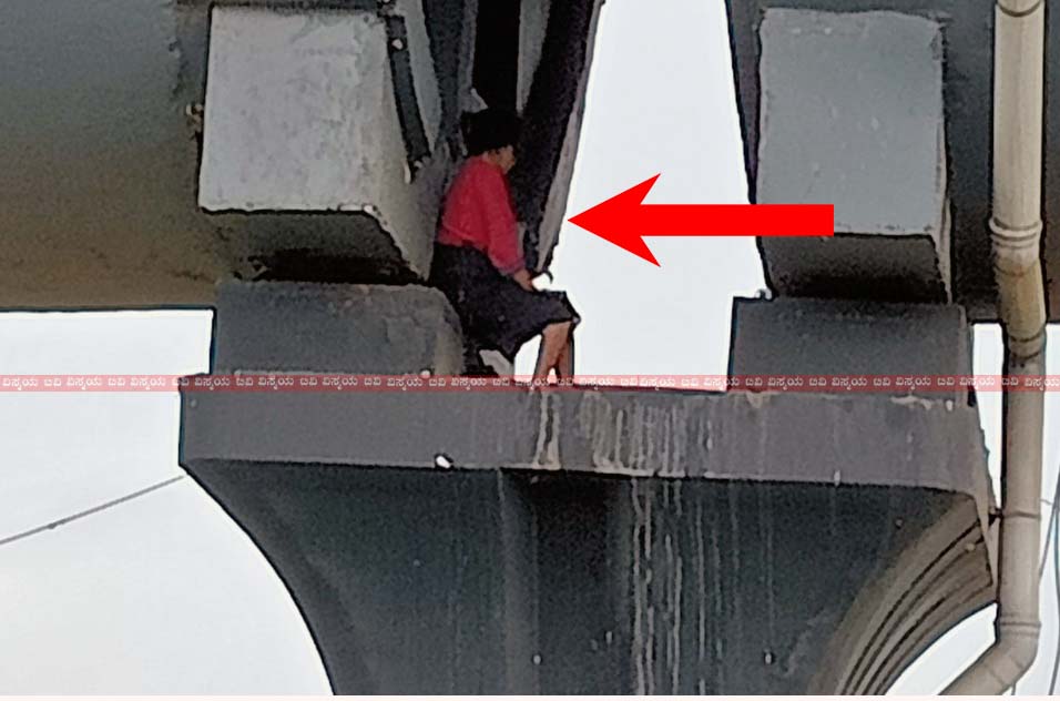 A woman was sitting between the pillars of the flyover